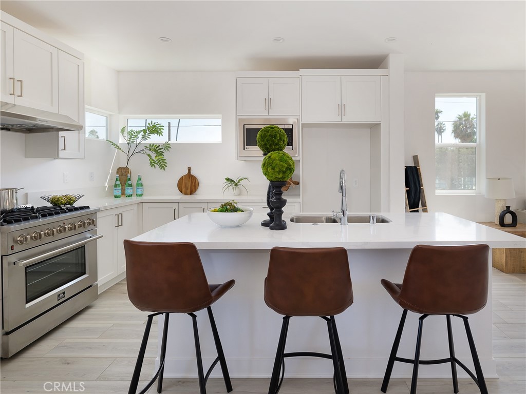 121 East 223rd Street, Unit 1 Carson, CA 90745 - Photo 10 of 35 a kitchen with stainless steel appliances a dining table chairs and granite counter tops