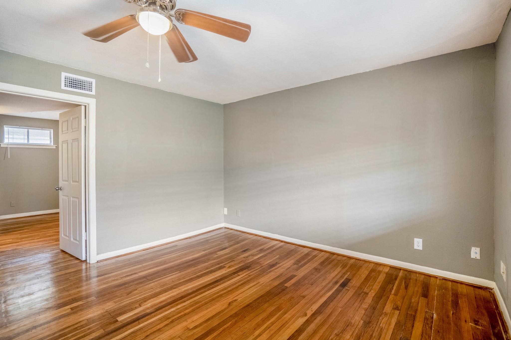 4720 Delano Street Houston, TX 77004 - Photo 7 of 12 wooden floor in an empty room with a window