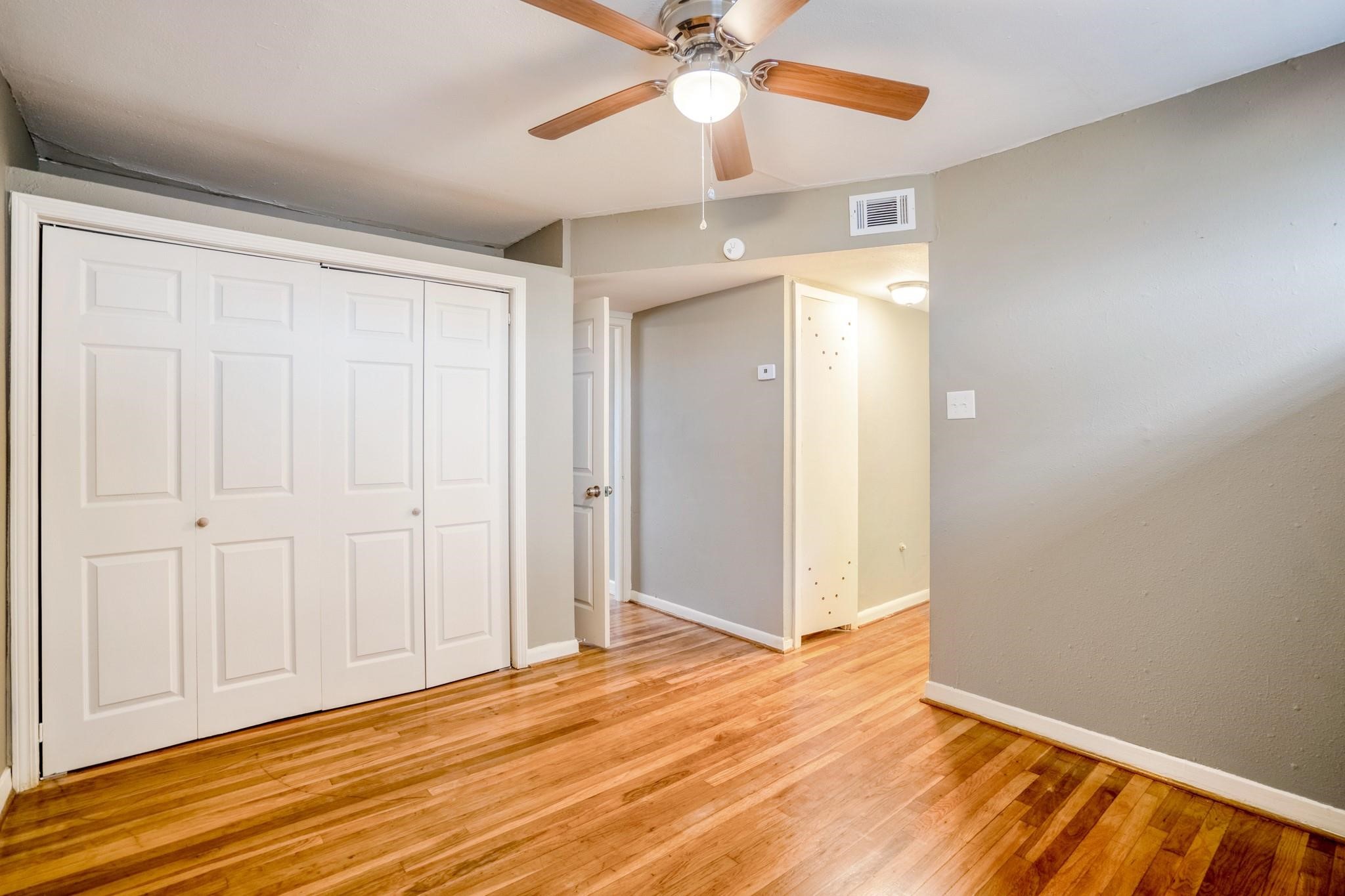 4720 Delano Street Houston, TX 77004 - Photo 9 of 12 an empty room with wooden floor fan and windows