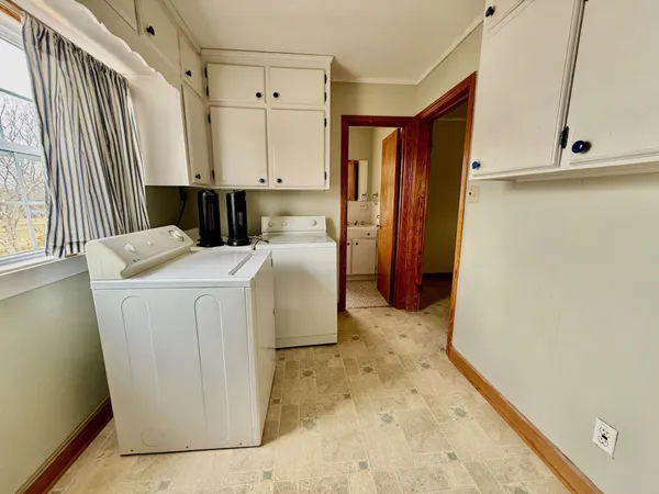 a utility room with cabinets washer and dryer
