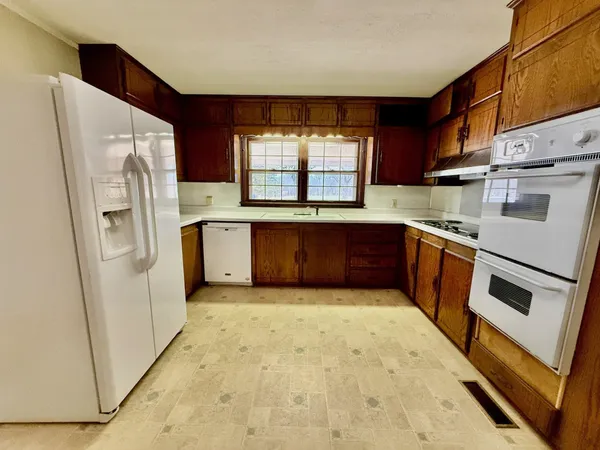 a kitchen with stainless steel appliances granite countertop a refrigerator a sink a stove and island