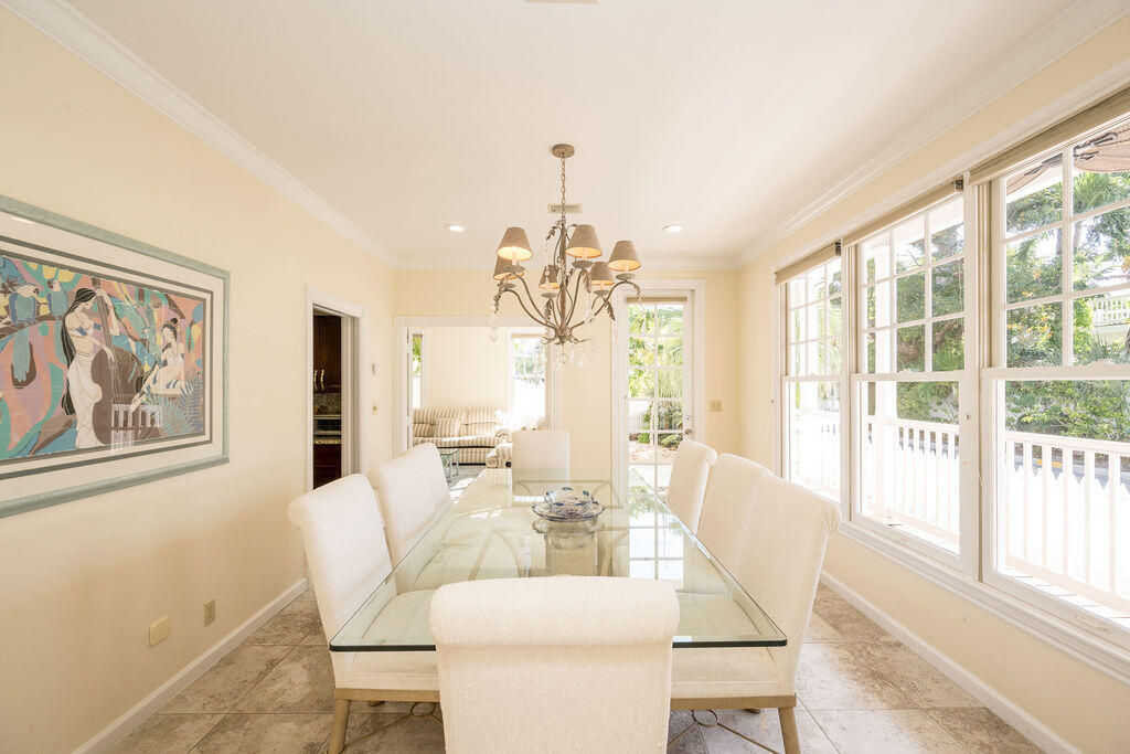 202 Admirals Lane Key West, FL 33040 - Photo 14 of 59 a dining room with wooden floor a chandelier a glass table and chairs