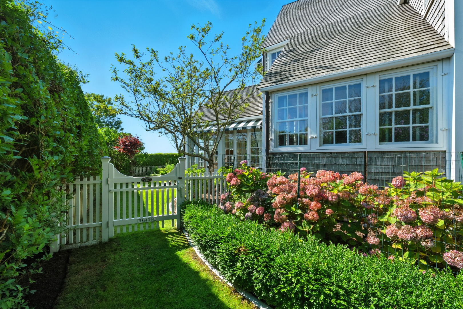 1 Ocean Avenue Nantucket, MA 02554 - Photo 46 of 49 a front view of a house with a garden