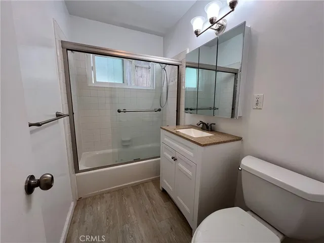 a bathroom with a sink a mirror a toilet and shower