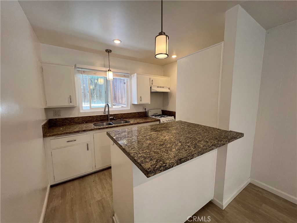25091 La Cresta Drive, Unit B Dana Point, CA 92629 - Photo 6 of 30 a kitchen with stainless steel appliances granite countertop a sink and a wooden floor