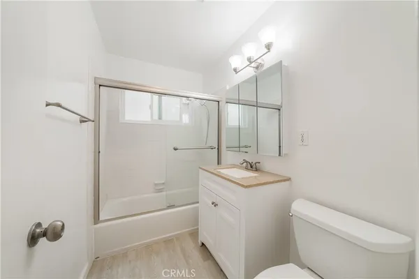 a bathroom with a granite countertop sink a toilet and shower