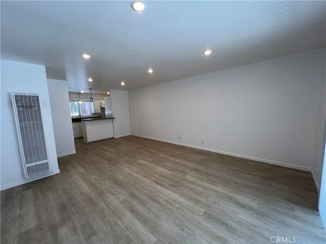 an empty room with wooden floor and a window