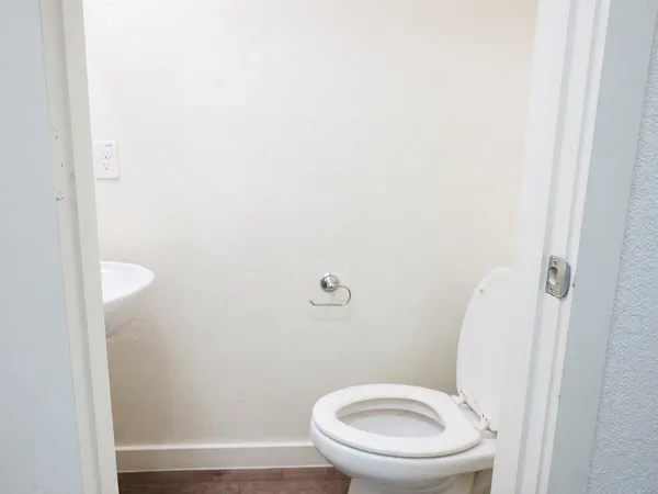 a white toilet sitting next to a shower