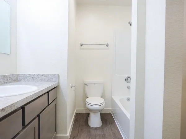 a bathroom with a granite countertop toilet and a sink