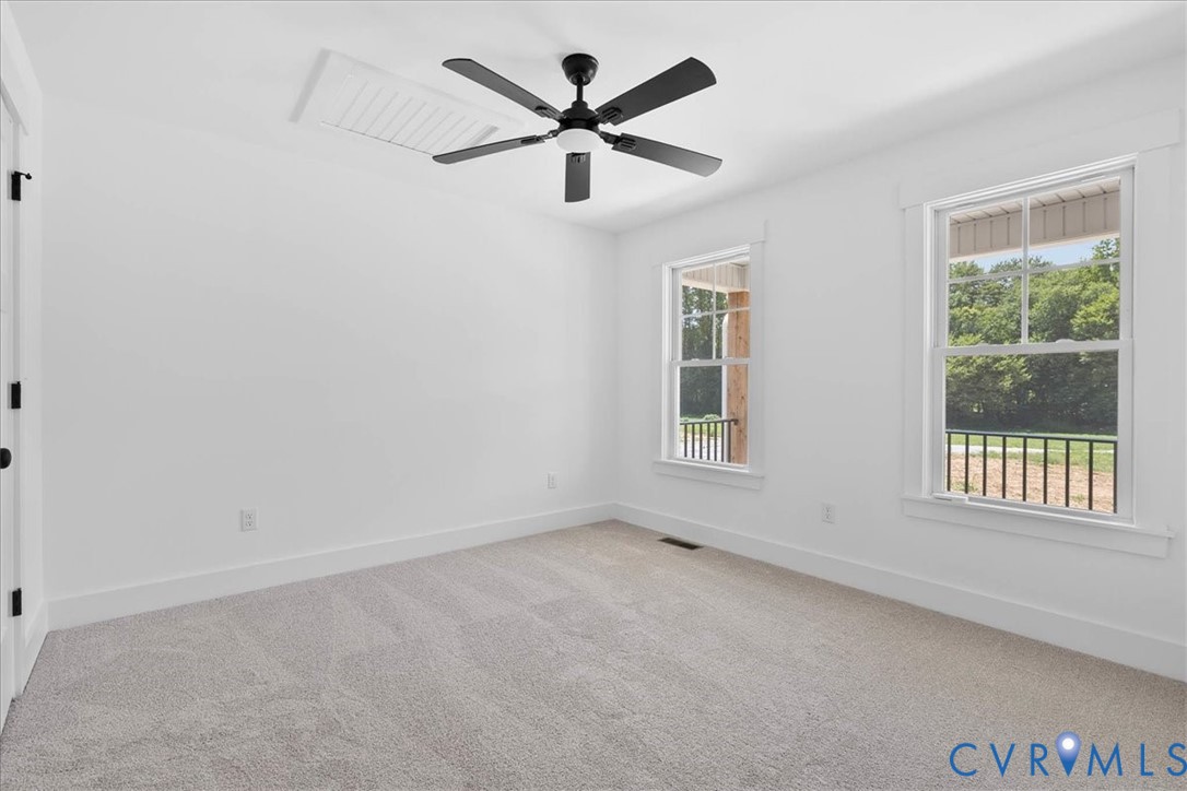 20055 Log Road Disputanta, VA 23842 - Photo 17 of 27 an empty room with chandelier fan and windows