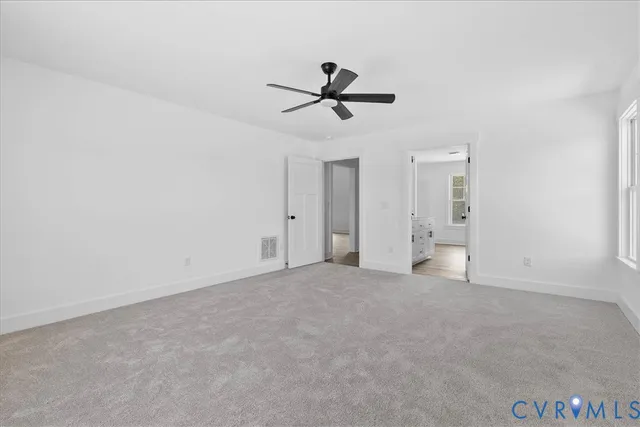 an empty room with closet and windows