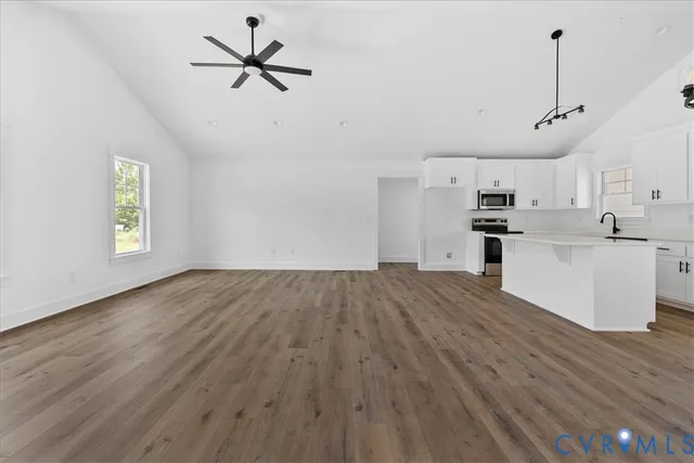 a view of a kitchen with a sink dishwasher a refrigerator and wooden floor