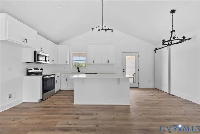 a large kitchen with white cabinets and stainless steel appliances
