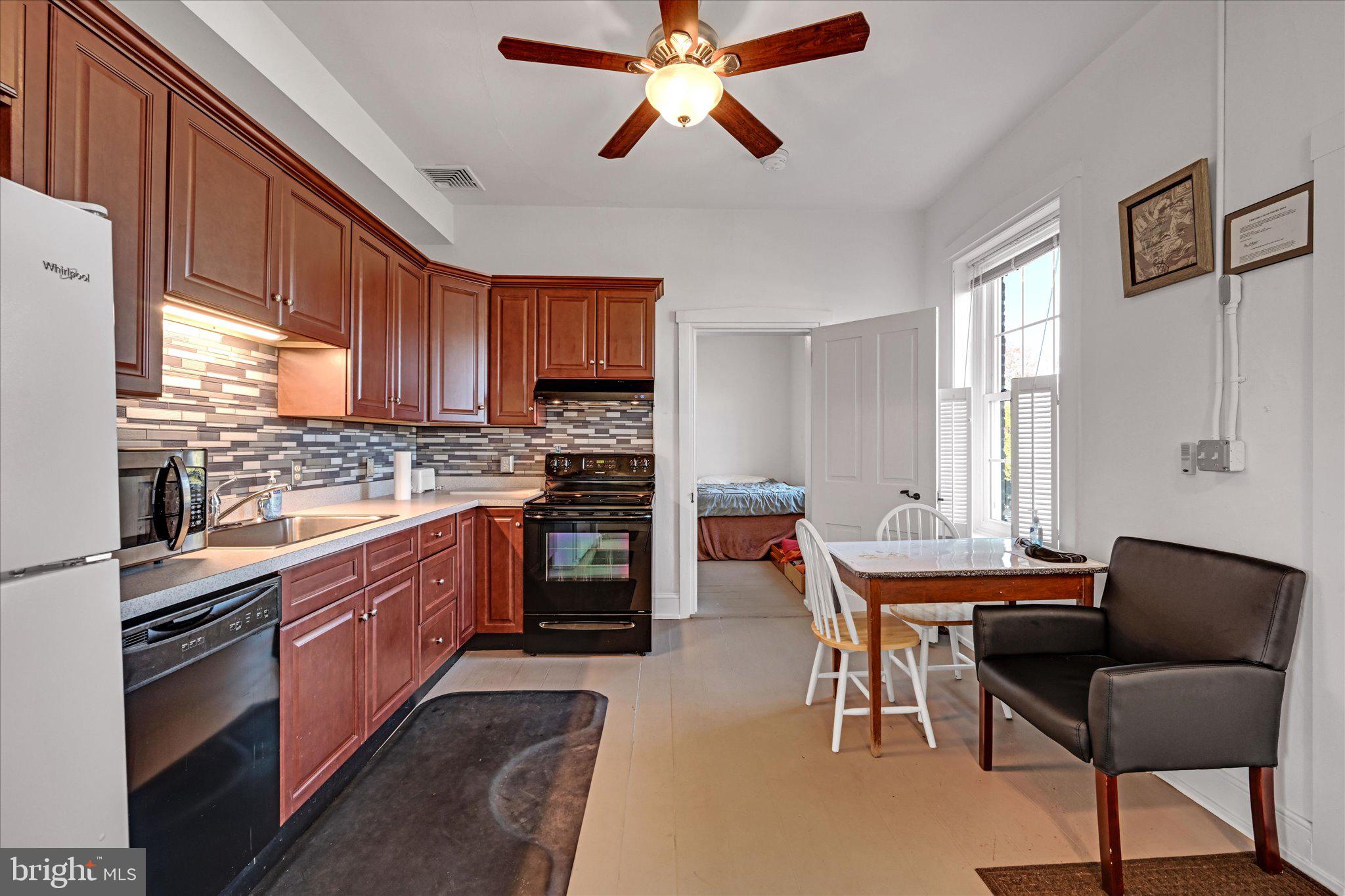 1530 New Holland Road Reading, PA 19607 - Photo 11 of 28 a kitchen with stainless steel appliances kitchen island granite countertop a stove top oven a sink with a dining table and chairs