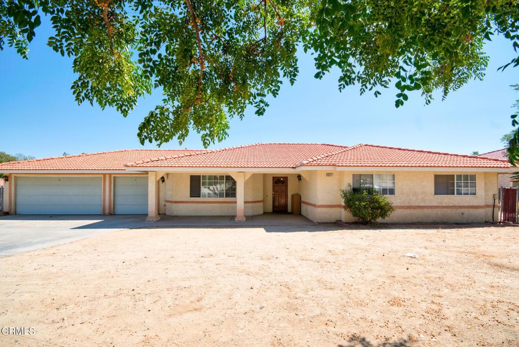 a front view of house with yard and trees in the background