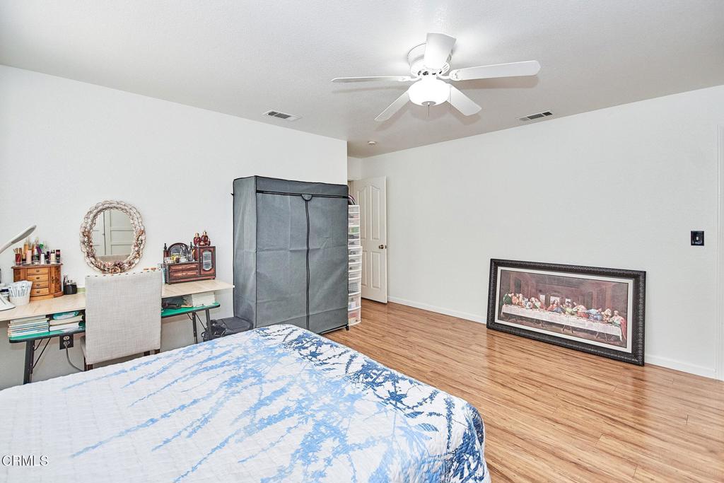 9527 Riggins Road Phelan, CA 92371 - Photo 25 of 49 a bedroom with a bed and a dresser with wooden floor