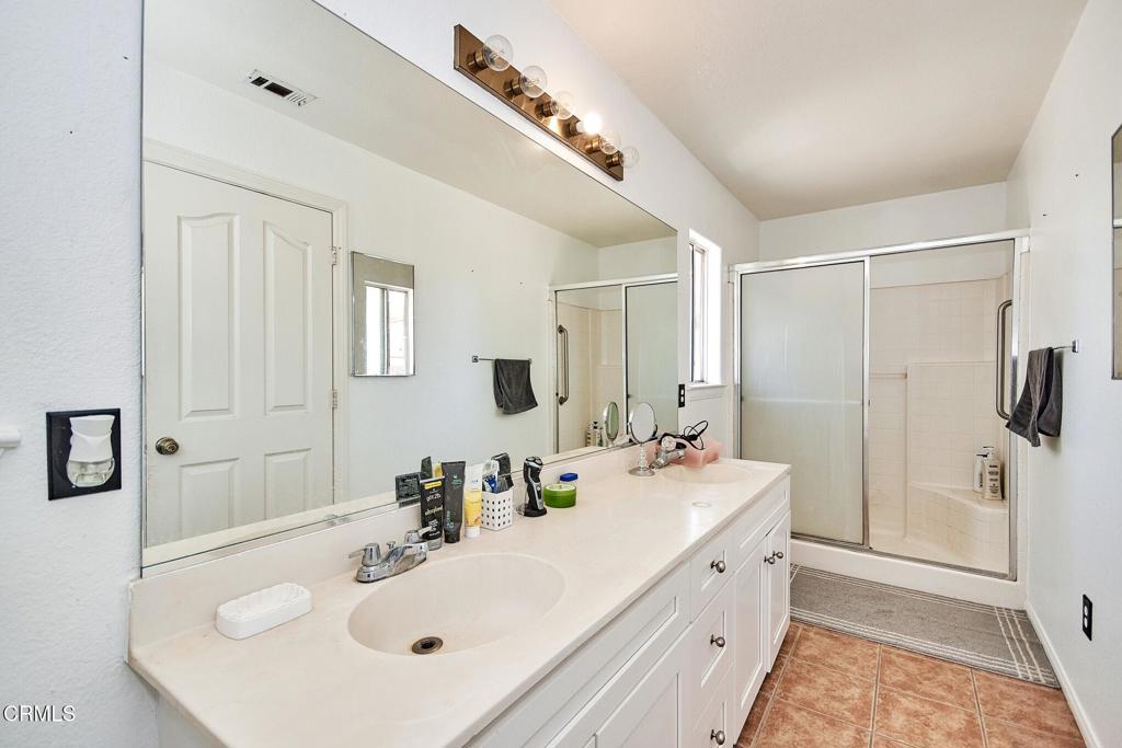 9527 Riggins Road Phelan, CA 92371 - Photo 26 of 49 a bathroom with a sink a mirror and a shower