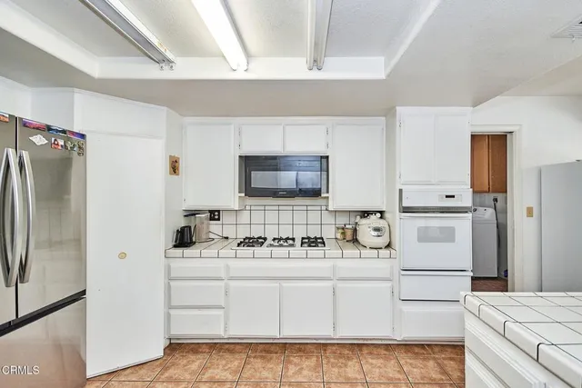 a kitchen with white cabinets and white appliances