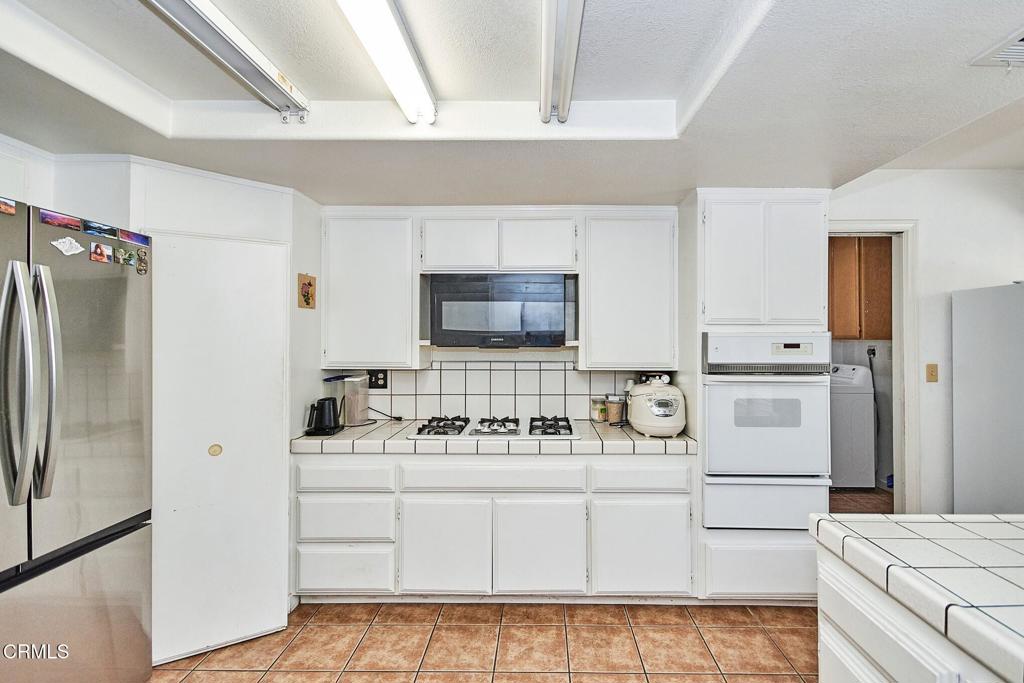 9527 Riggins Road Phelan, CA 92371 - Photo 35 of 49 a kitchen with white cabinets and white appliances