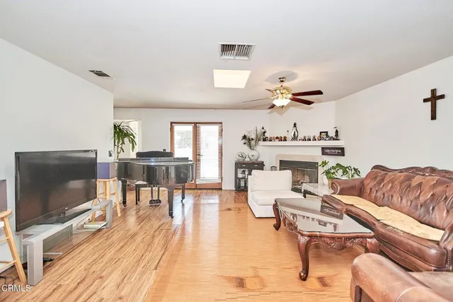 a living room with furniture a flat screen tv and kitchen view