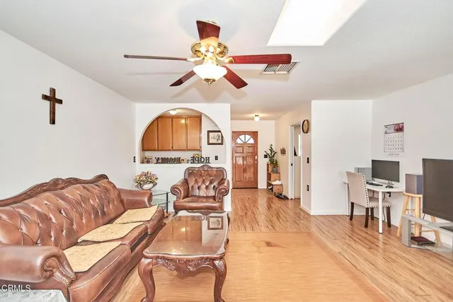 a living room with furniture a ceiling fan and a window