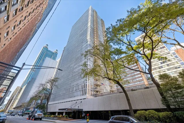 a view of a tall building with large tree