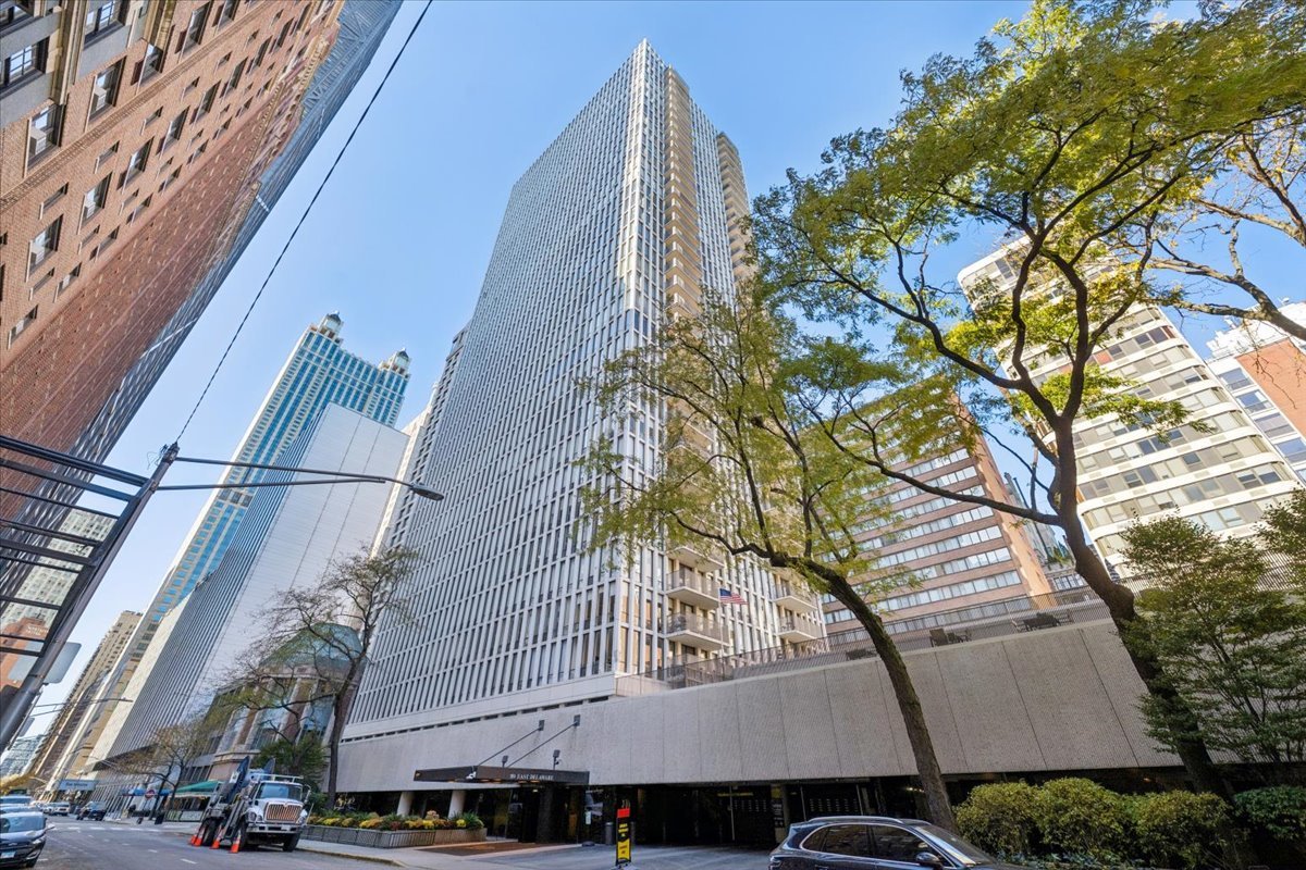 a view of a tall building with large tree