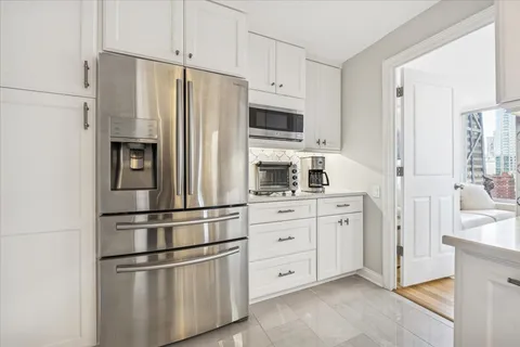a kitchen with stainless steel appliances white cabinets and a refrigerator