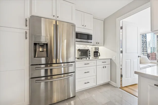 a kitchen with stainless steel appliances white cabinets and a refrigerator