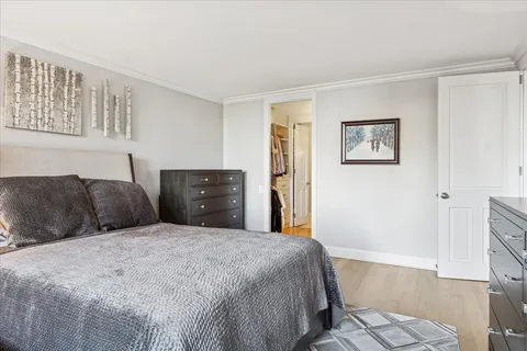 a large bedroom with a bed and wooden floor