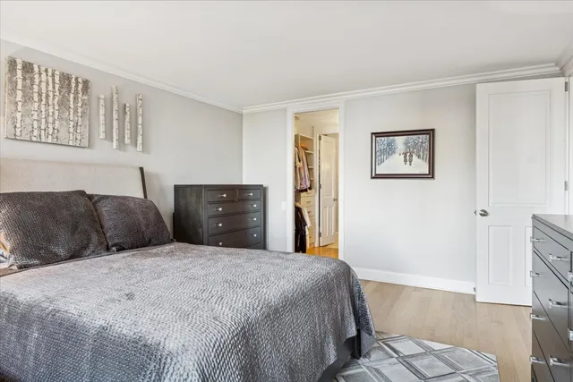 a large bedroom with a bed and wooden floor