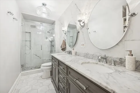 a bathroom with a granite countertop sink mirror vanity and toilet
