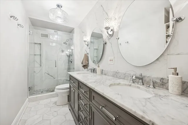 a bathroom with a granite countertop sink mirror vanity and toilet