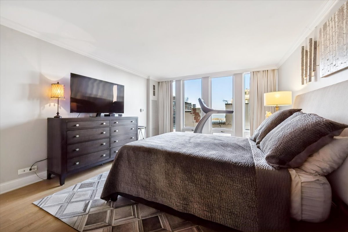 200 East Delaware Place, Unit 20A Chicago, IL 60611 - Photo 20 of 46 a bed room with a bed and a television