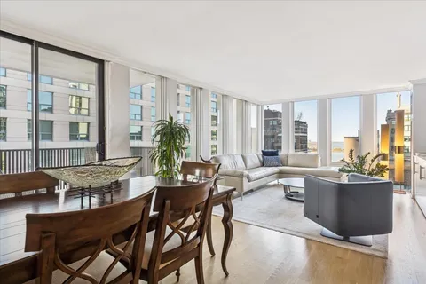 a view of a dining room with furniture large windows and wooden floor