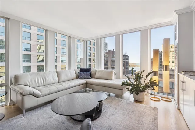 a living room with furniture and floor to ceiling windows