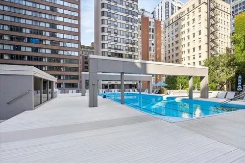 a view of pool with outdoor seating and city view