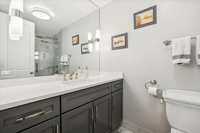 a bathroom with a sink mirror vanity and toilet