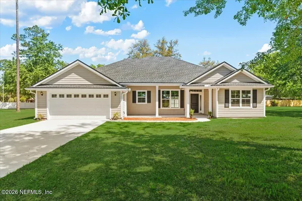 a white house that has a tree in front of it