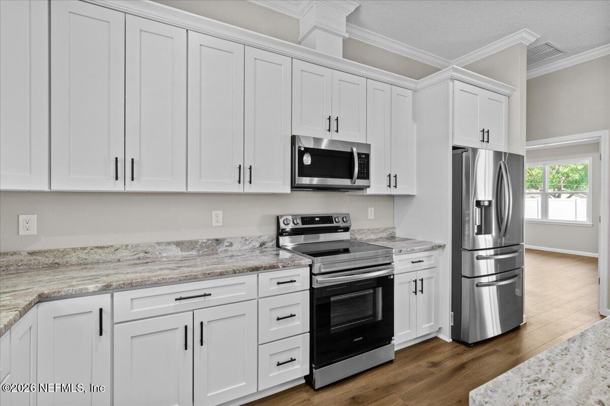 2462 Viola Street Middleburg, FL 32068 - Photo 13 of 61 a kitchen with granite countertop white cabinets and stainless steel appliances