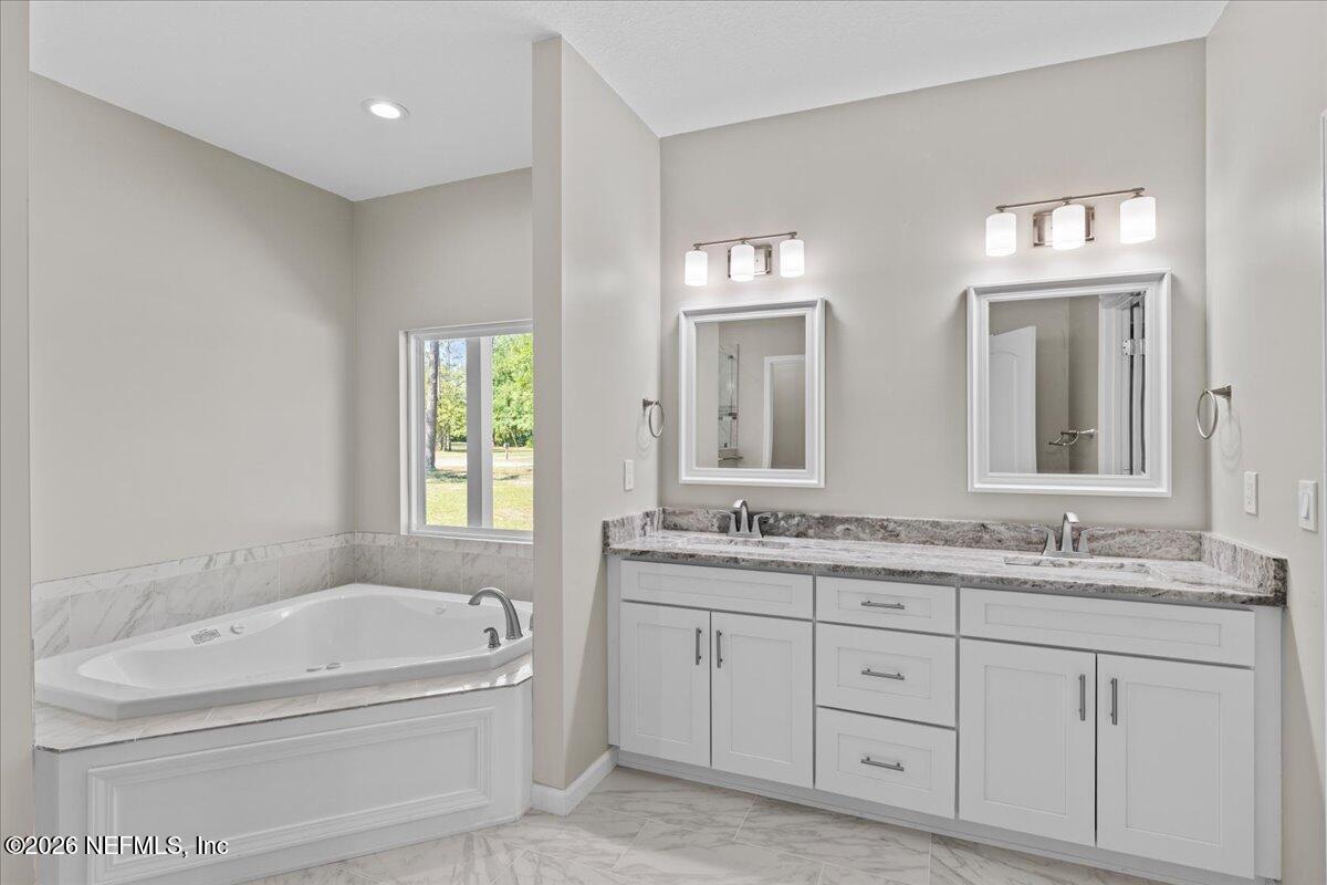 2462 Viola Street Middleburg, FL 32068 - Photo 19 of 61 a bathroom with a granite countertop tub a double vanity sink a window and a mirror