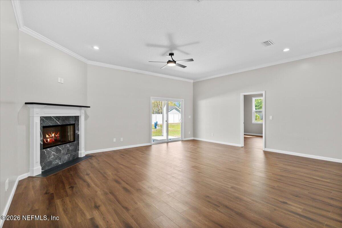2462 Viola Street Middleburg, FL 32068 - Photo 26 of 61 an empty room with wooden floor fireplace and windows
