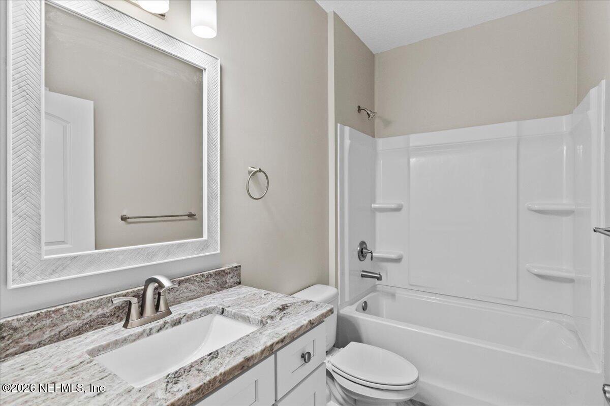 2462 Viola Street Middleburg, FL 32068 - Photo 30 of 61 a bathroom with a granite countertop sink toilet tub and shower