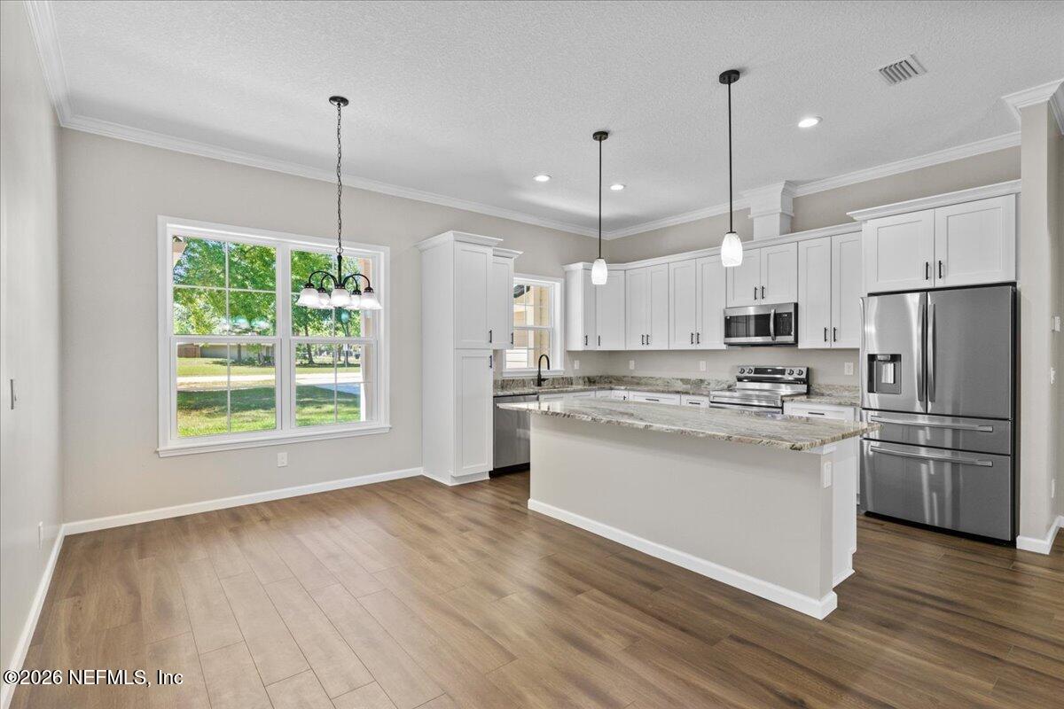 2462 Viola Street Middleburg, FL 32068 - Photo 10 of 61 a kitchen with stainless steel appliances granite countertop a refrigerator a stove a sink and a wooden floor