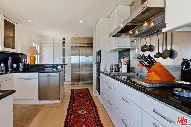 a kitchen with stainless steel appliances granite countertop a sink stove and cabinets