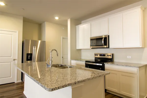 a kitchen with stainless steel appliances granite countertop a sink a microwave and stove