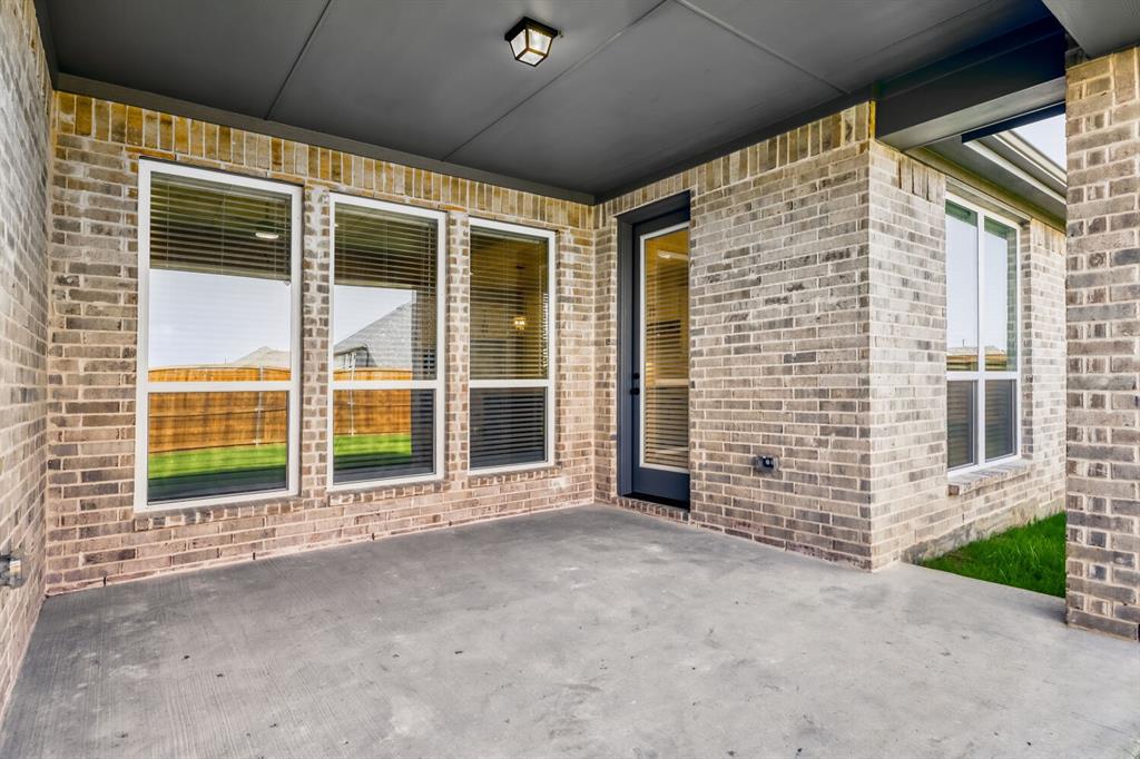 4314 Haley Way Oak Point, TX 75068 - Photo 24 of 28 Covered concrete patio with a dark ceiling and recessed lighting, featuring a brick exterior wall