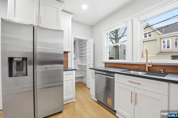 a kitchen with stainless steel appliances granite countertop a refrigerator and a sink