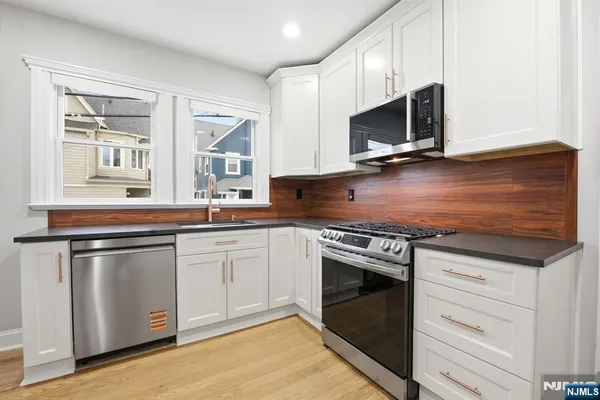 a kitchen with stainless steel appliances granite countertop a stove a microwave and a sink
