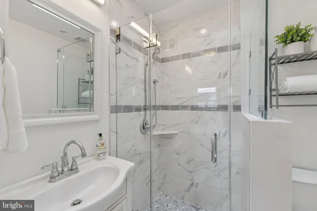 a bathroom with a sink shower and a mirror